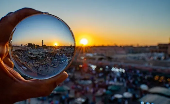 Sunset reflected through a glass sphere above a city